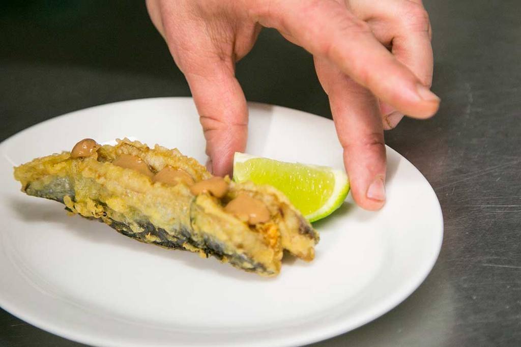 Rallamos un poco de piel de lima sobre las sardinas y las acompañamos con un trocito de lima para aportar acidez al escurrirla justo antes de comerla.