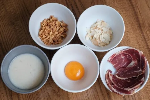 Alcachofas braseadas al vino blanco con vinagreta de jamón ibérico, yema de huevo, almendra y cebolla frita