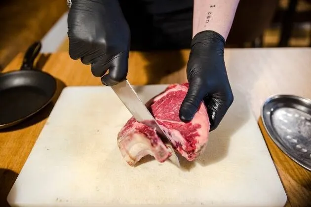 Berenjena a la llama, gamba blanca en grasa de txuleta madurada y caldo de cebollas asadas