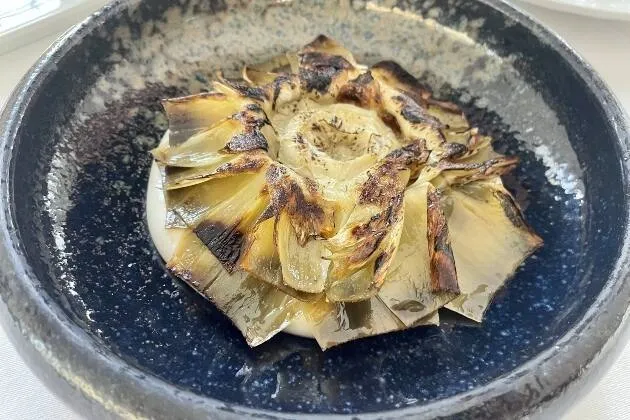 Alcachofa confitada, praliné salado de cacahuete, velo de papada y cremoso de patata 