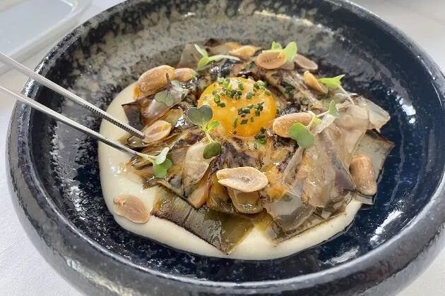 Alcachofa confitada, praliné salado de cacahuete, velo de papada y cremoso de patata 