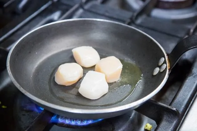 Vieiras a la brasa con crema de guisantes, coco y aceite cítrico