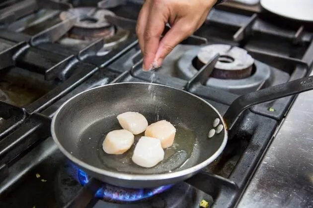 Vieiras a la brasa con crema de guisantes, coco y aceite cítrico