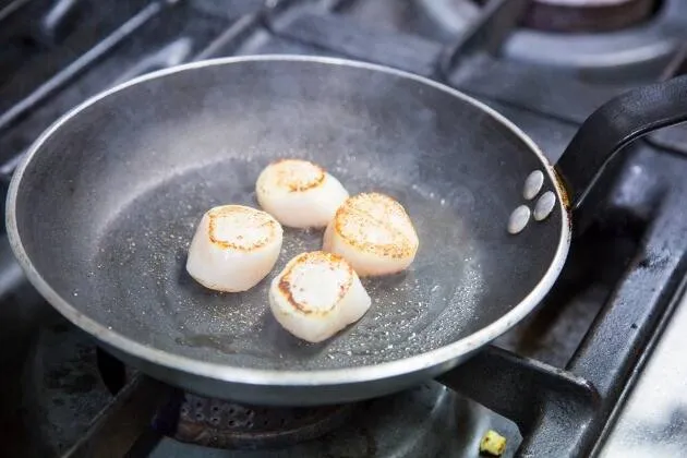 Vieiras a la brasa con crema de guisantes, coco y aceite cítrico