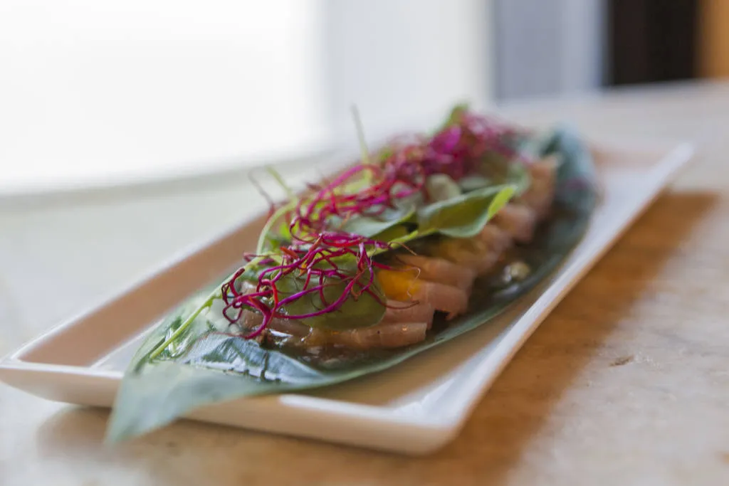 Sashimi de bonito curado en casa con hoja de shiso, berros y ponzu de maracuyá