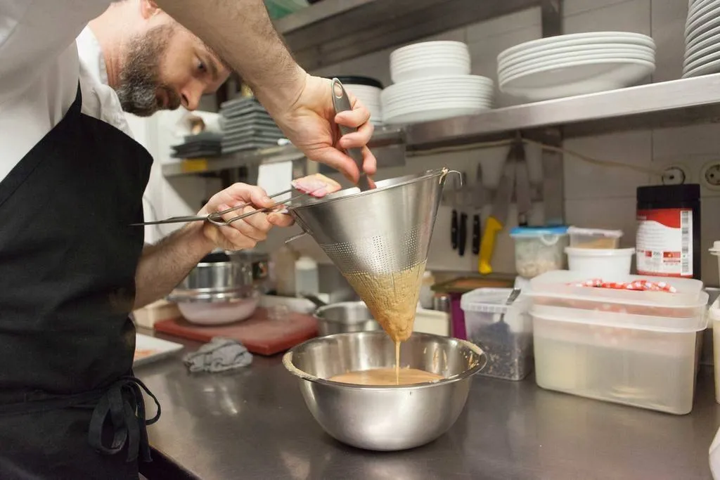 Colocar en la thermomix o en un recipiente para batidora los trozos de foie y la crema de leche hervida y mezclar. Si hace falta, dar previamente un punto de calor para que el foie no esté completamente crudo y se deshaga mejor. Pasar la mezcla por un cedazo o un colador chino para evitar que queden restos de venas del foie y para conseguir una textura homogénea y fina.