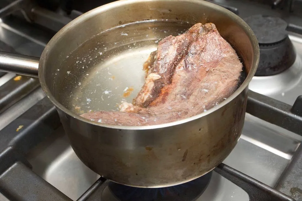 Poner la lengua dentro de una cazuela, cubrirla con agua fría y llevarla a ebullición para limpiarla. 