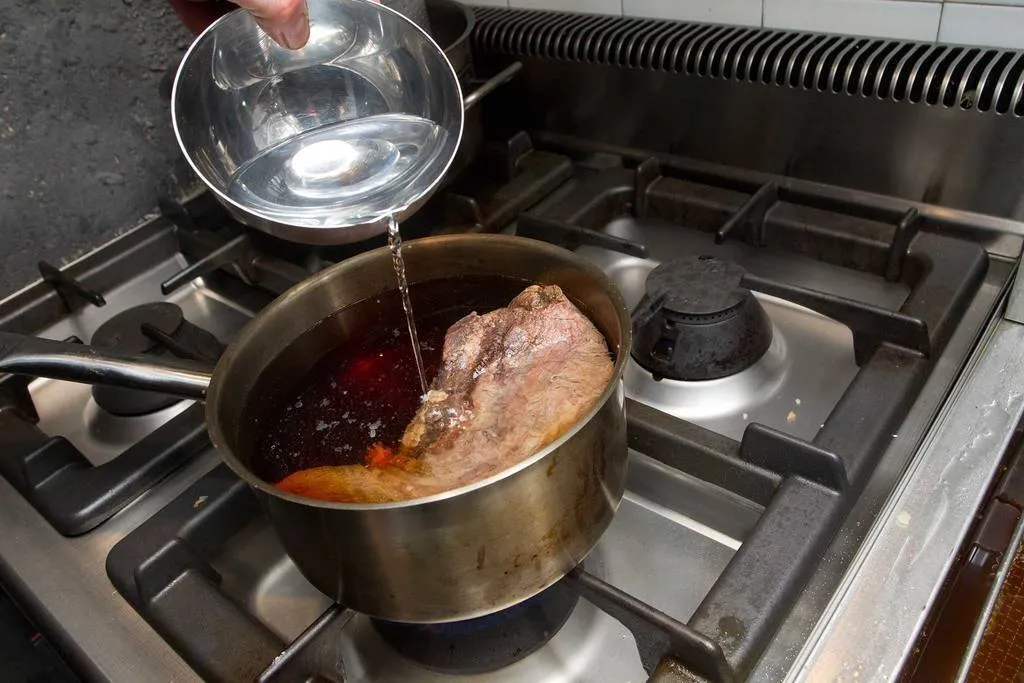 Lavarla con agua fría, cubrirla otra vez con agua, y añadir el sake, el dashi y el bonito.