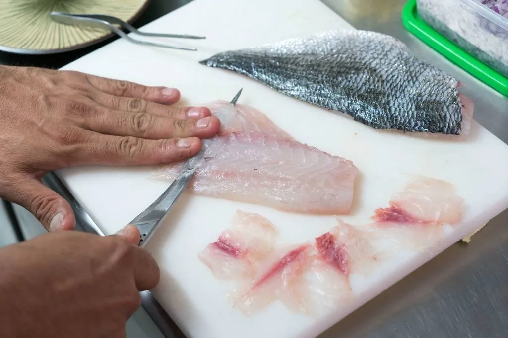 Cortar en pequeños filetes la lubina y bañar con la marinada de mango. 