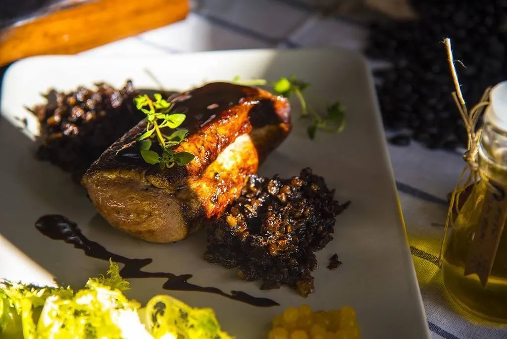 Servimos el solomillo napado con la salsa y acompañado por la duxelles y los piñones (opcional).