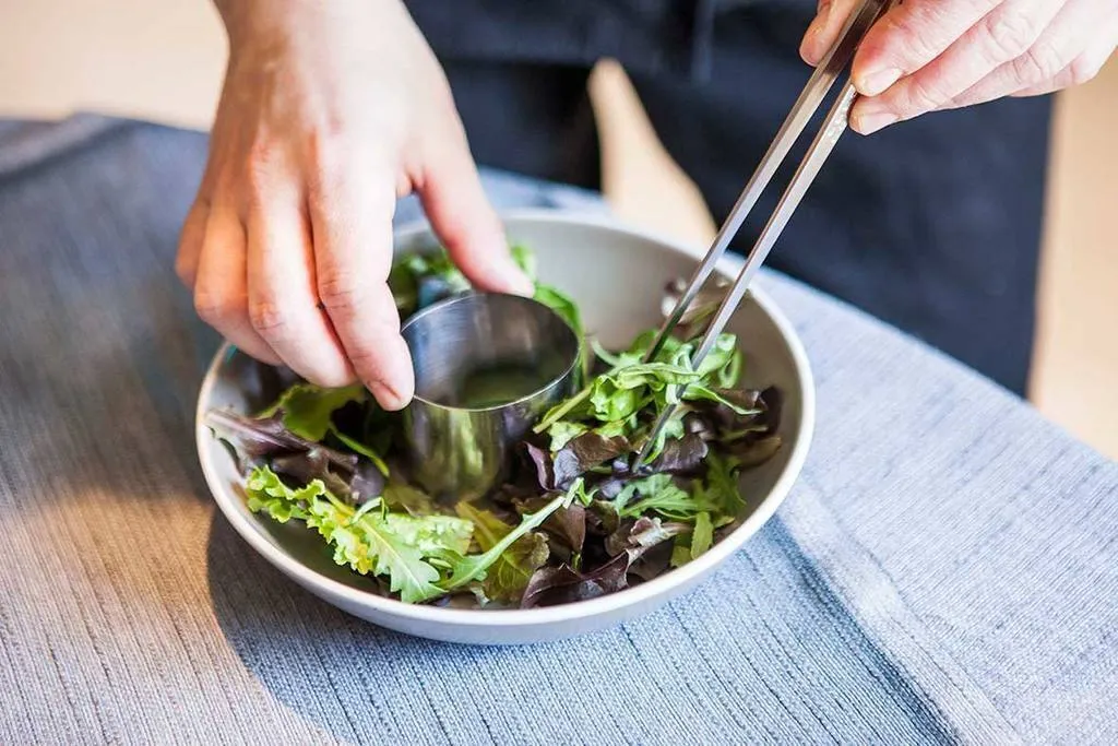 Disponemos sobre un plato un lecho con los brotes de lechuga y, en su centro, colocamos un molde redondo pequeño.