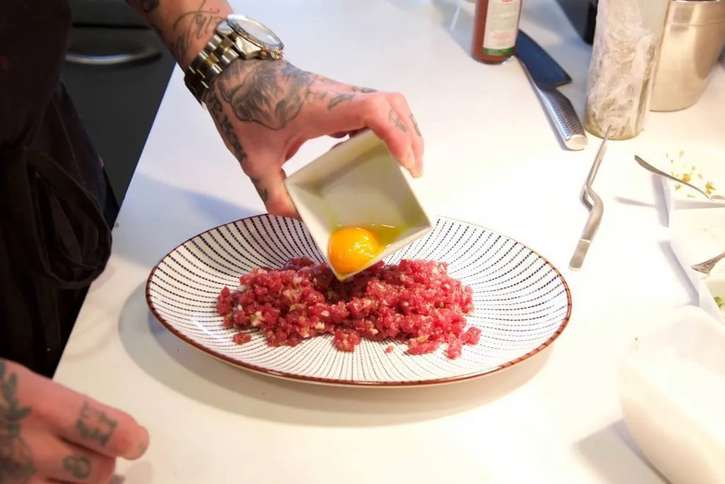 Terminar emplatando el tartar de atún con la yema de huevo en el centro 