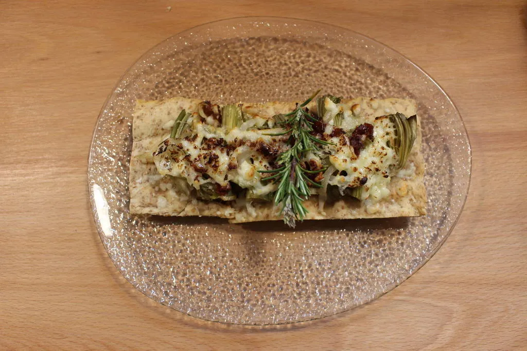 Coca salada con alcachofas, tomate seco y queso fresco