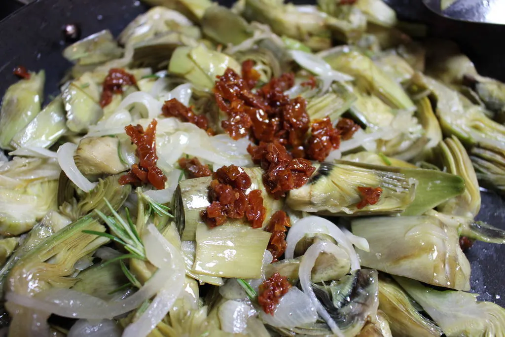 Coca salada con alcachofas, tomate seco y queso fresco