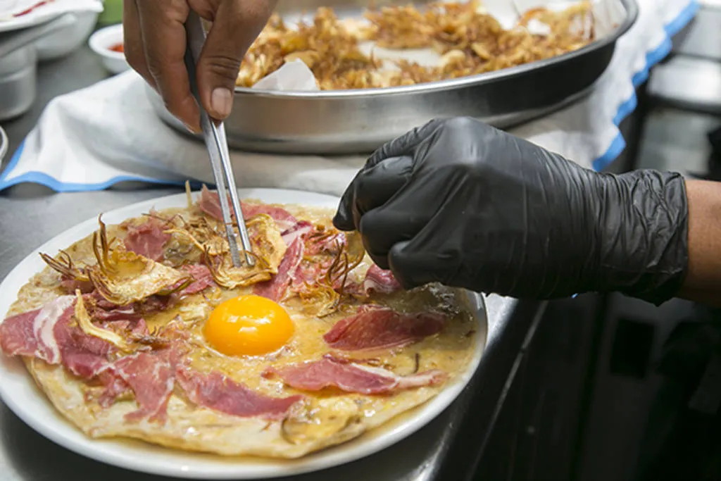 Tortilla abierta de chips de alcachofa, jamón ibérico y yema ahumada al romero