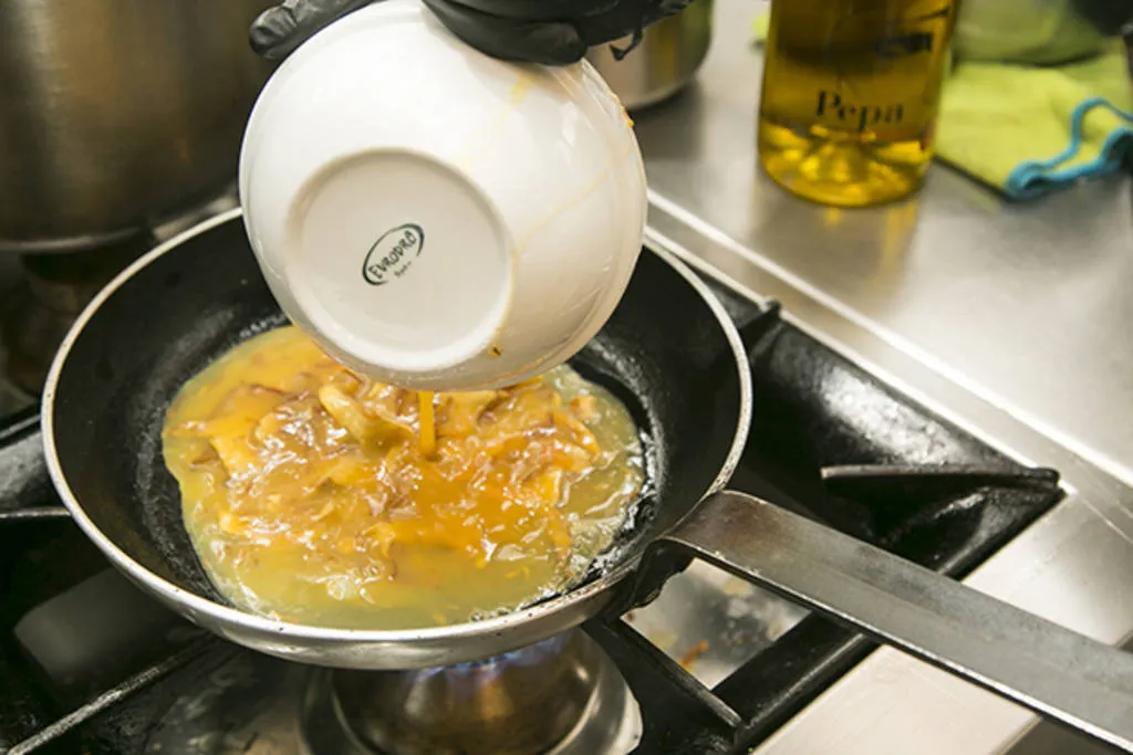 Tortilla abierta de chips de alcachofa, jamón ibérico y yema ahumada al romero