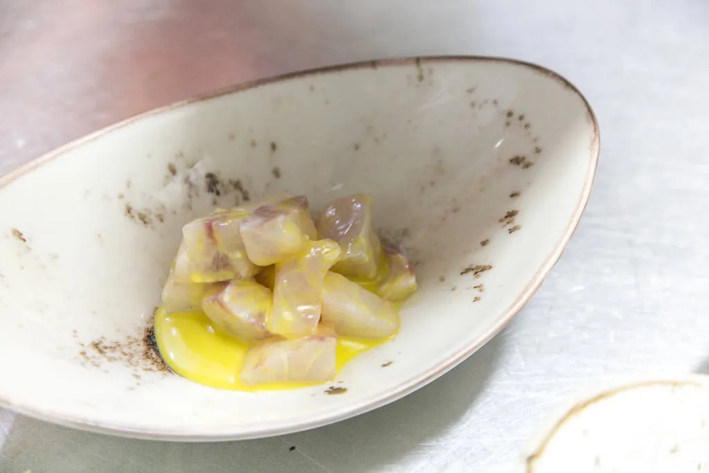 Ceviche de corvina con ají amarillo, aguacate y kikos 