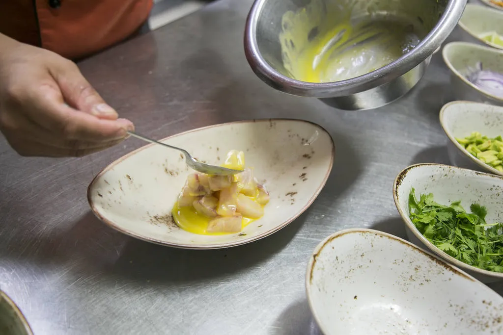 Ceviche de corvina con ají amarillo, aguacate y kikos 