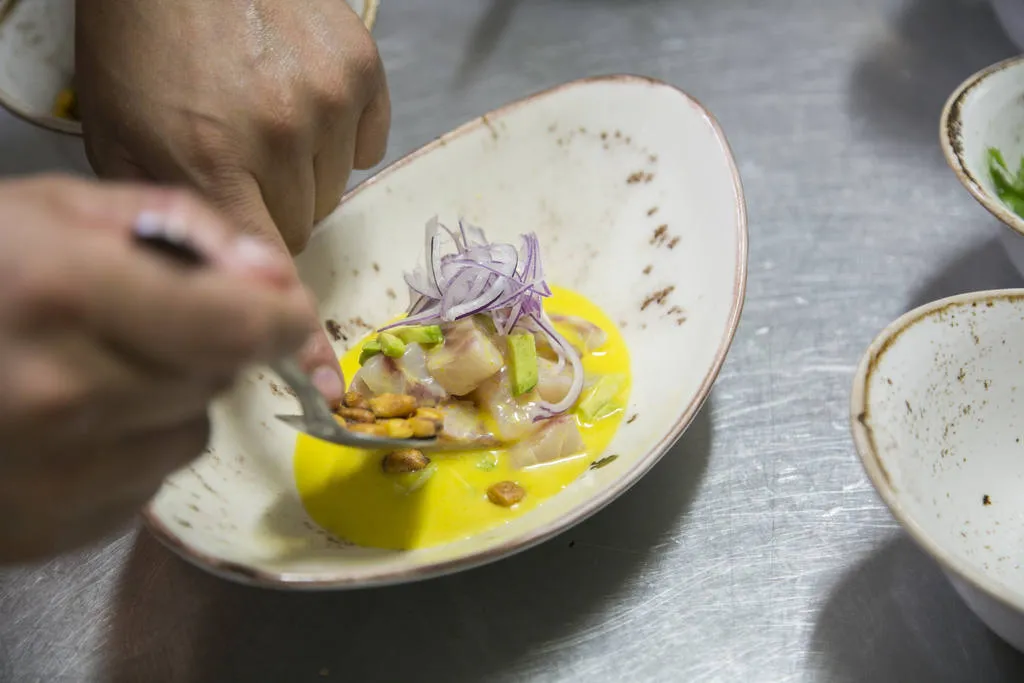 Ceviche de corvina con ají amarillo, aguacate y kikos 