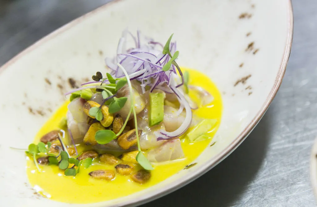 Ceviche de corvina con ají amarillo, aguacate y kikos 