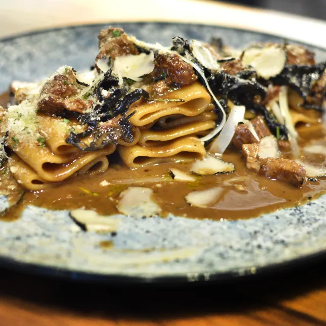 Paccheri con cordero, trompetas de la muerte y trufa negra