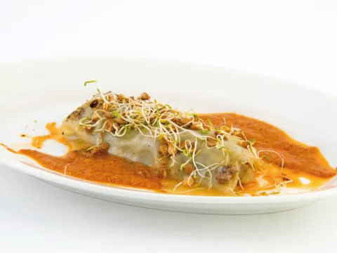 Canelón de berenjena en tártar con anchoas, romesco y vinagreta de oro