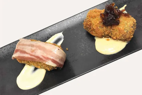 Dúo de croquetas de chipirones con crema de ajo y panceta ibérica curada, y de rustido de pollo y foie con bechamel de cebolla de Figueres y cebolla caramelizada