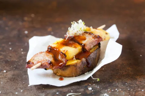 Brocheta de secreto ibérico con piña, patata asada y salsa teriyaki