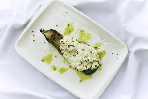 The WineStracciatella: Berenjena cremosa ahumada con Straciatella de burrata, praliné de frutos secos y mojo verde.