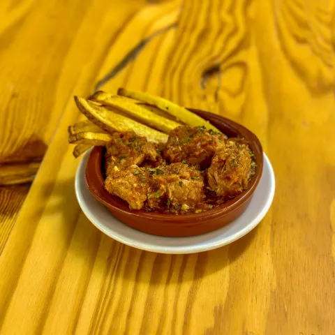 Guiso antiguo de carne de cerdo troceada con salsa de tomate casera