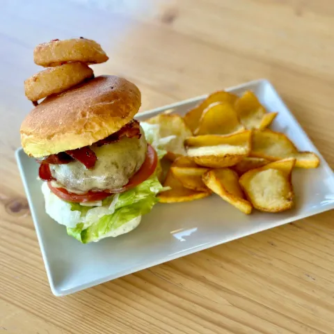 Suculenta mini hamburguesa 100 x 100 Black Angus con nuestro bacon crispy, aros de cebolla, queso especial ahumado y salsa de albahaca