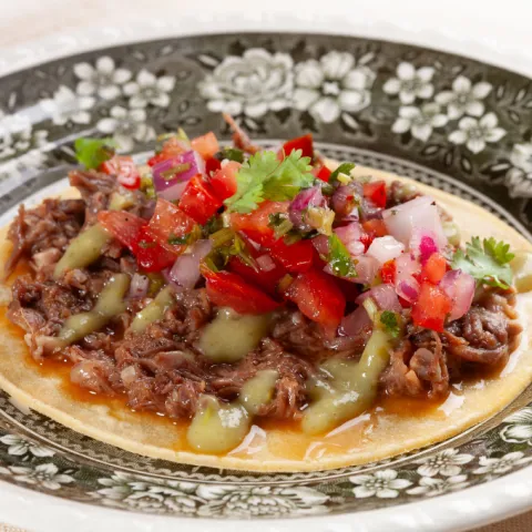 Taco con carrillera de cerdo confitada, pico de gallo y guacamole.