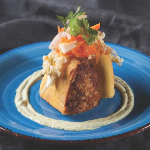 Pan de pita casero de ají amarillo relleno de pollo especiado y verduritas del Parc Agrari y salsa tártara