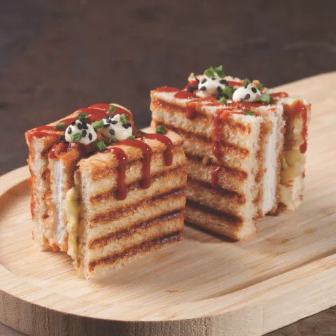Pan de molde con chuleta de cerdo rebozada con panko, salsa tonkatsu, col del Parc Agrari, aceite de sésamo, salsa mayostaza y cebollino