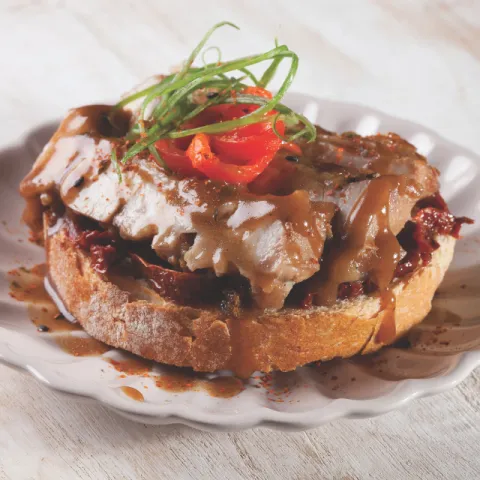 Tostada de pan de payés con tomates del Parc Agrari confitados a fuego lento y pollo jugoso con salsa de cerveza dorada