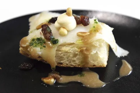 Tosta de bacalao ahumado con piñones y pasas con reducción de Oporto