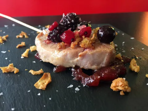 Piruleta de cerdo ibérico con mermelada de frutas del bosque y cebolla crujiente