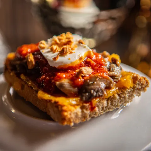 Tostada de pan con crema de albaricoque, boletus, salsa de sobrasada, queso blanco y almendra picada