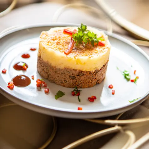 Pastel de frit de cerdo y puré de patata con salsa de pimiento rojo