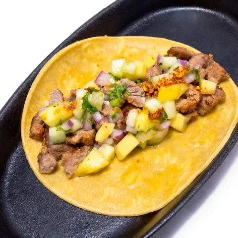 Taco de carnita aderezado con salsa Macha