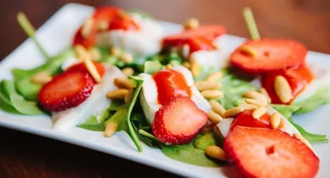 Dorada marinada con espinacas, fresas, albahaca y piñones