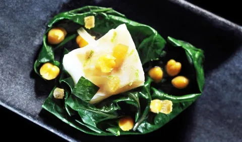 Bacalao con garbanzos y miso sobre un nido de acelgas